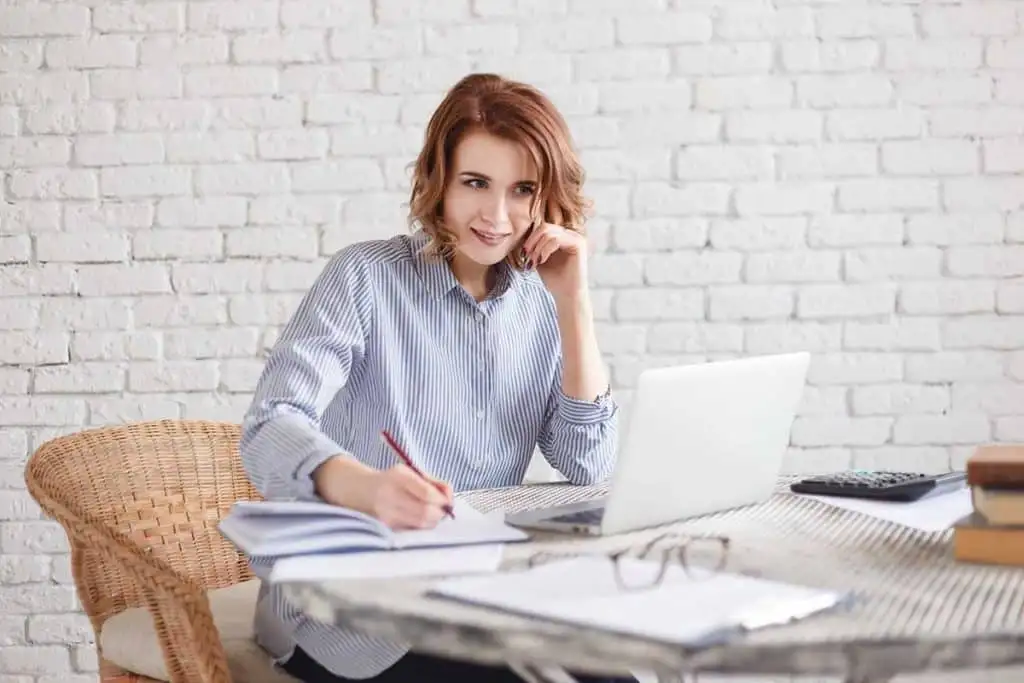 happy smiling woman freelancer write A girl writing notes about the research