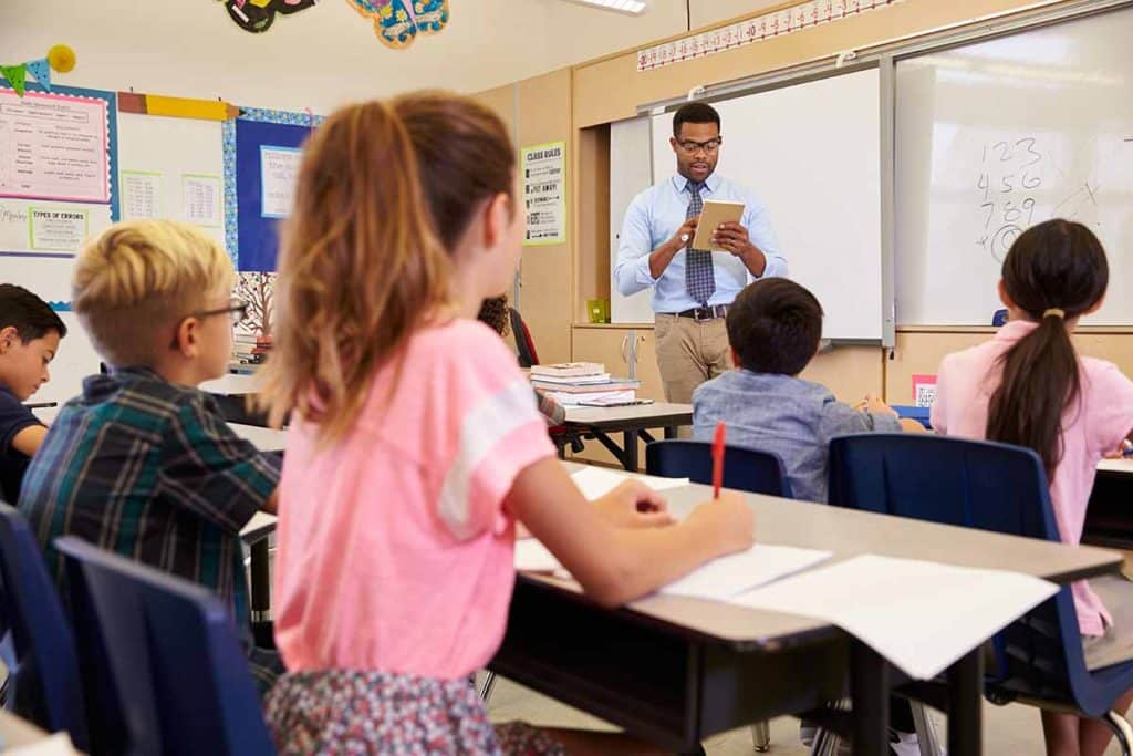 Profesor utilizando tablet PC en una clase de escuela primaria
