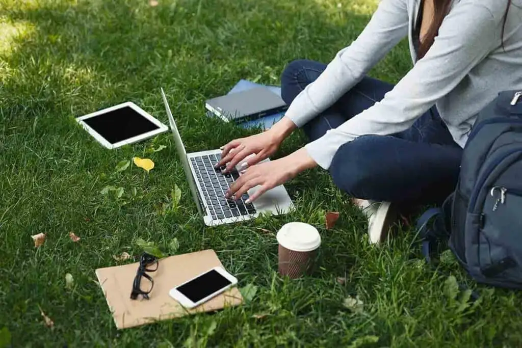 young pensive woman using laptop in park PFNSYT Young woman using laptop in park