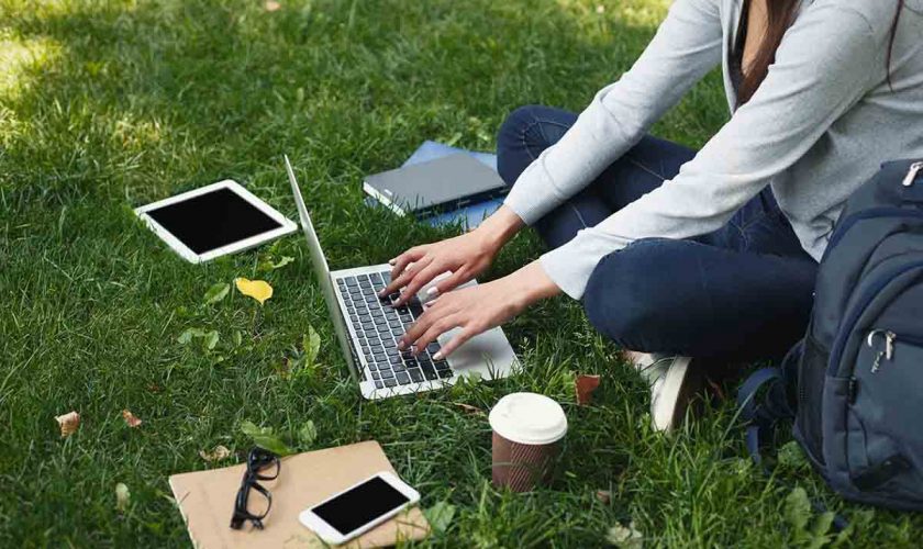 Young woman using laptop in park