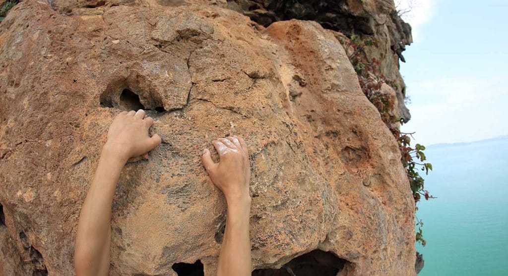 young woman rock climber hands climbing at seaside mountain cliff rock