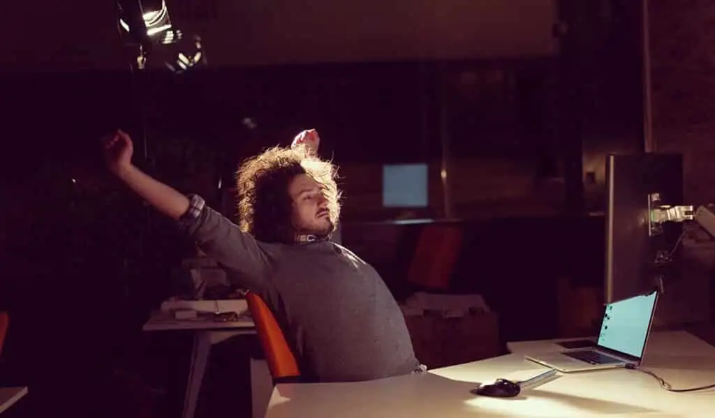 man working on computer Young man working on computer at night in dark office.