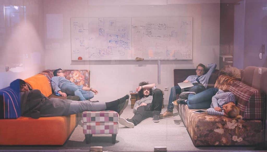 software developers sleeping on sofa in creative startup office