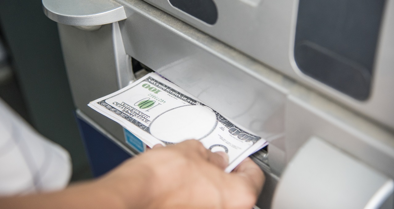 Closeup of a hand getting money from an ATM