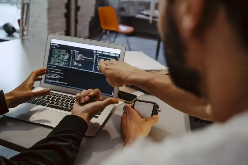 Two people coding laptop office b